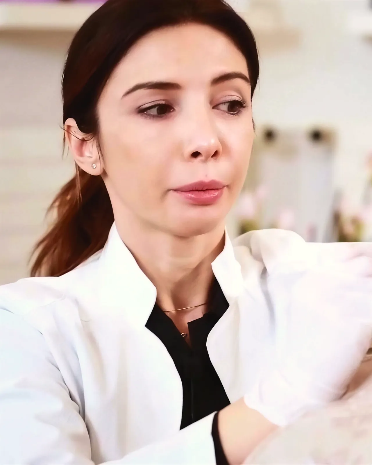 La Dott.ssa Laura Balint in camice bianco, durante un trattamento, ascolta con attenzione.